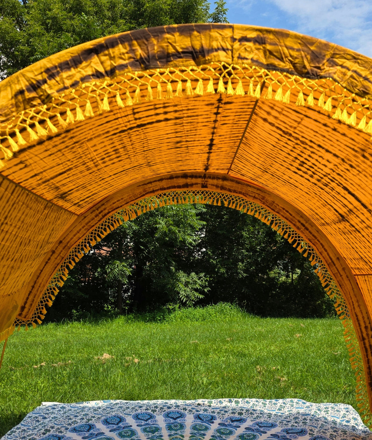 Yellow tie-dye Suniela SolarCotton™ shade cabana canopy providing UPF 50+ shade on the beach