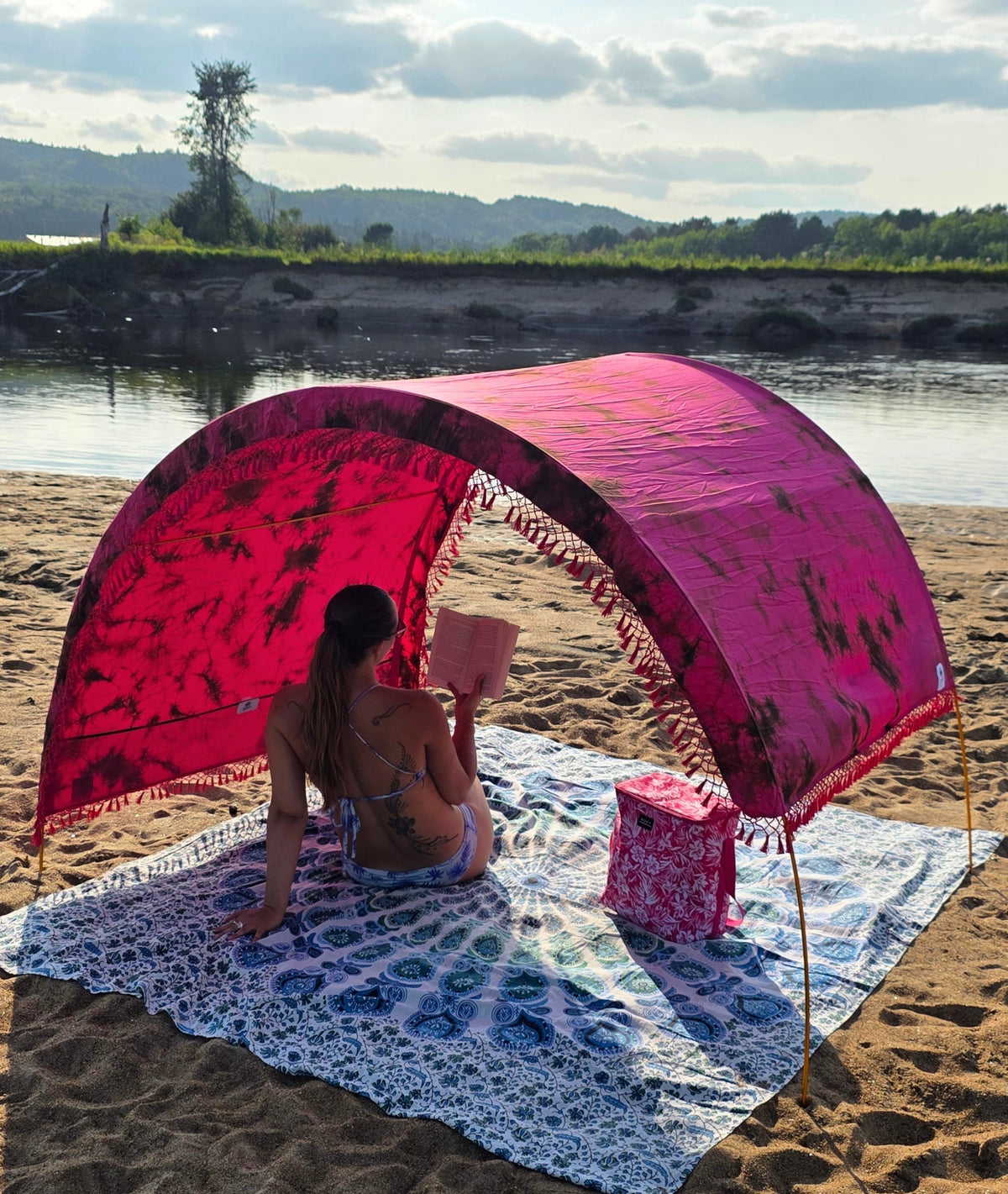Pink tie-dye Suniela SolarCotton™ shade cabana canopy set up on a sunny beach
