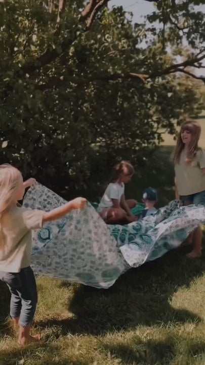 kids playing with Suniela cotton picnic blanket in the grass